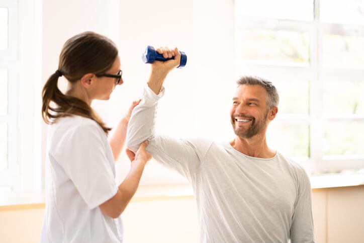 Physical Rehabilitation Therapist Helping Man. Physiotherapy Rehabilitation